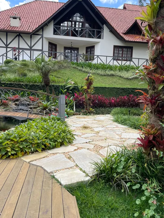 Jardim com caminho de pedras, gramado e canteiros floridos