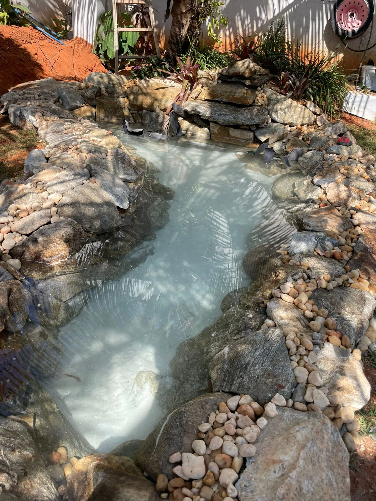 Lago ornamental em construção com pedras naturais