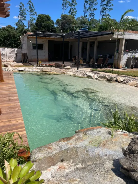 Piscina natural residencial com pedras e deck